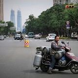 Home Delivery  I find this picture characteristic for Kunming in two ways:  1. The towers in the back symbolize the incredible construction activity going on in town. There are huge constructions sites in every other block. We wondered where the money for these new buildings come from and who will actually live / work in the in the end.  2. Gas and water bottles seem to be delivered solely by motorcycles. Coming from Vietnam, one is not so much impresseed by the huge cargo, but rather wonders if it would not be much more convenient to have a little truck for this sort of delivery. But then again, it's just a lot faster to move through the city on motorbike than by car...